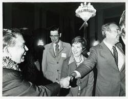 ["Black and white photograph print of Carl Albert shaking hands with an unidentified man at his birthday party, 1976"]