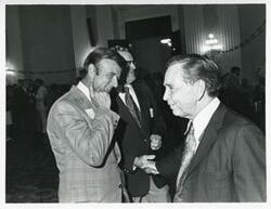 ["Black and white photograph print of  Albert shaking hands with an unidentified man at his birthday party, 1976"]