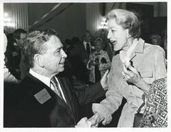 ["Black and white photograph print of Carl Albert speaking with Millicent Fenwick at his birthday party, 1976"]