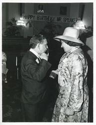 ["Black and white photograph print of Carl Albert speaking with Bella Abzug at his birthday party, 1976"]