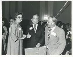 ["Black and white photograph print of Carl Albert speaking with Irene Oney and Joseph P. Addabbo at his birthday party, 1976"]