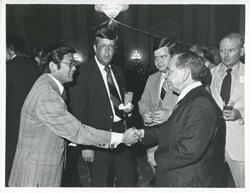 ["Black and white photograph print of Carl Albert with an unidentified people at his birthday, 1976"]