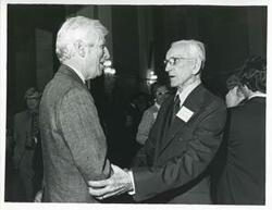 ["Black and white photograph print of John W. McCormack shaking hands with an unidentified man at Carl Albert's birthday party, 1976"]