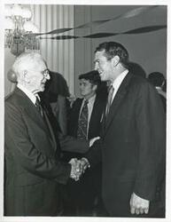 ["Black and white photograph print of John W. McCormack shaking hands with an unidentified man at Carl Albert's birthday party, 1976"]