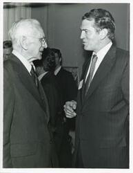 ["Black and white photograph print of John W. McCormack shaking hands with an unidentified man at Carl Albert's birthday party, 1976"]