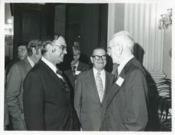 ["Black and white photograph print of John W. McCormack shaking hands with an unidentified man at Carl Albert's birthday party, 1976"]