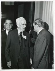 ["Black and white photograph print of John W. McCormack shaking hands with an unidentified man at Carl Albert's birthday party, 1976"]