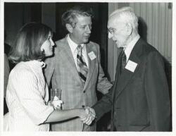 ["Black and white photograph print of John W. McCormack shaking hands with an unidentified woman at Carl Albert's birthday party, 1976"]