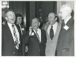 ["Black and white photograph print of Roy Harris, Carl Albert, John Brademas, and John W. McCormack speaking with one another at Albert's birthday party, 1976"]