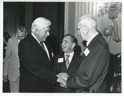 ["Black and white photograph print of Thomas P. O'Neill, Carl Albert, and John W. McCormack shaking hands at Albert's party, 1976"]