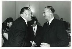 ["Black and white photograph print of Mike Mansfield shaking hands with an unidentified man at Carl Albert's birthday party. May 10, 1974"]