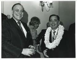 ["Black and white photograph print of Carl Albert shaking hands with an unidentified man at his birthday party. May 10, 1974"]