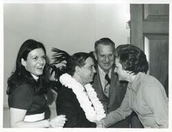 ["Black and white photograph print of Carl Albert shaking hands with an unidentified woman as John N. Happy Camp looks on. This is at Albert's birthday party. May 10, 1974"]