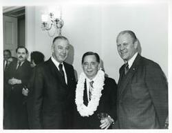 ["Black and white photograph print of Carl Albert, Gerald R. Ford, and another man posing at Albert's birthday party. May 10, 1976"]