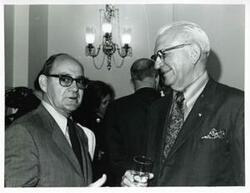 ["Black and white photograph print of two unidentified men speaking at Carl Albert's birthday party. May 10, 1974"]