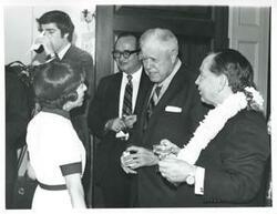 ["Black and white photograph print of Mary Albert, W. R. Poage, Carl Albert, and others talking at Albert's birthday party. May 10, 1974"]