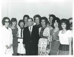 ["Black and white photograph print of Carl Albert posing with Mary Albert, Helen Newman Tuttle, Jane England Lawton, Sue Thomson, Tamara Kitchens and others at his birthday party. May 10, 1974"]
