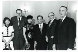 ["Black and white photograph print of Carl Albert posing with Mary Albert and Mike Mansfield and others at his birthday party. May 10, 1974"]