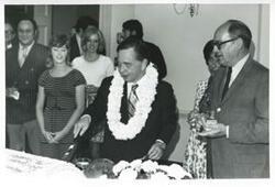 ["Black and white photograph print of Carl Albert cutting the cake at his birthday party. May 10, 1974"]