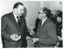 ["Black and white photograph print of two unidentified men talking at Carl Albert's birthday party. May 10, 1974"]