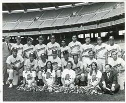 ["Black and white photograph print of Carl Albert posing with congressional baseball team and cheerleaders. 1972"]