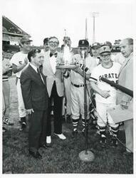 ["Black and white photograph print of Carl Albert standing on the field with others at the congressional baseball game."]
