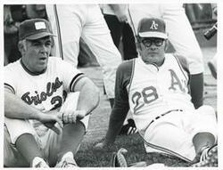 ["Black and white photograph print of Clem McSpadden and another baseball player seated on the ground."]