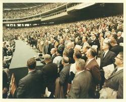 ["Color photograph print of Lyndon B. Johnson throwing in the baseball at a baseball game. Also pictured is Charles Halleck, Everett Dirksen, Lyndon B. Johnson, Hale Boggs, Hubert Humphrey, Lawrence F. O'Brien, George D. Aiken, John W. McCormack, and Carl Albert. 1964"]