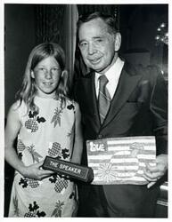 ["Black and white photograph print of Carl Albert posing with an unidentified girl in his office."]