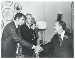 ["Black and white photograph print of Carl Albert shaking hands with an unidentified person."]