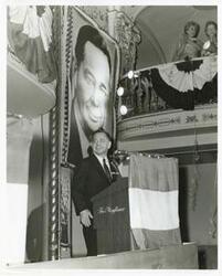 ["Black and white photograph print of Carl Albert speaking at a podium."]
