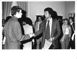 ["Black and white photograph print of Arthur Ashe shaking hands with an unidentified man. 1975"]
