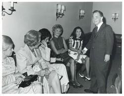 ["Black and white photograph print of Carl Albert speaking with unidentified women."]