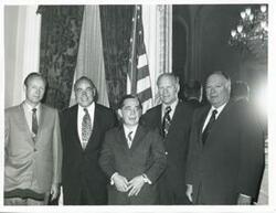 ["Black and white photograph print of Carl Albert, Gerald R. Ford, and three other men."]