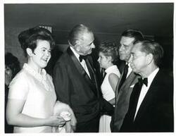 ["Black and white photograph print of Carl Albert, Gerald R. Ford, and two other men seated at a dinner table."]
