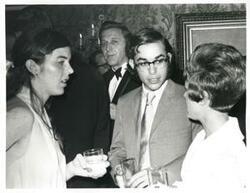 ["Black and white photograph print of Unidentified people speaking to one another."]