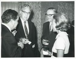 ["Black and white photograph print of Carl Albert speaking with two unidentified men."]