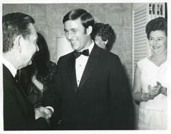 ["Black and white photograph print of Carl Albert shaking hands with an unidentified man."]