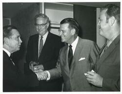 ["Black and white photograph print of Carl Albert shaking hands with an unidentified man."]
