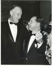 ["Black and white photograph print of Carl Albert shaking hands with an unidentified man."]