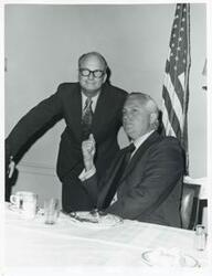 ["Black and white photograph print of Charles Ward and David Hall speaking to one another."]