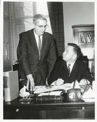 ["Black and white photograph print of Carl Albert speaking with unidentified people."]
