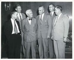 ["Black and white photograph print of Carl Albert, A. S. Mike Monroney, George Howard Wilson, Victor Wickersham, Tom Steed, and another man talking to each other. Circa 1949-1950."]