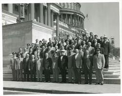 ["Black and white photograph print of Carl Albert, Olin Teague, Strom Thurmond, Robert L. F. Sikes, and several other people seated on the Capitol steps."]