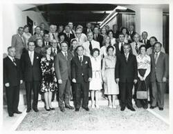 ["Black and white photograph print of Carl Albert and Mary Albert posing with a large group of people. House delegation trip. August 1975"]