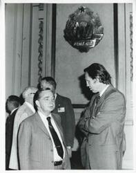 ["Black and white photograph print of Carl Albert speaking with an unidentified man. House delegation trip. August 1975"]