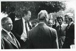 ["Black and white photograph print of Carl Albert standing and talking with several other men. House delegation trip. August 1975"]