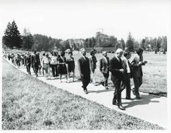 ["Black and white photograph print of Carl Albert with several others walking down a pathway during the House delegation trip. August 1975"]