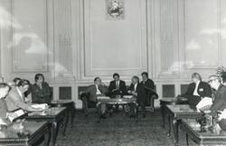 ["Black and white photograph print of Carl Albert seated with several other men during the House delegation trip. August 1975"]