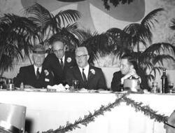 ["Black and white photograph print of Michael J. Kirwan, Earl Warren, and Carl Albert with another man at a St. Patrick's Day party."]